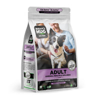 A bag of Adult, Overall Health & Wellness Formula Dog Food for Medium & Large Breeds Nature's Hug dog food is displayed. The packaging highlights "ADULT" and "Overall Health & Wellness." A playful dog sits in the foreground, and the background features happy pet owners interacting with the dog. Other labels emphasize sustainable protein and a chicken recipe.